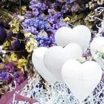 Foto: weiße Herzen vor blauen Stohblumen.